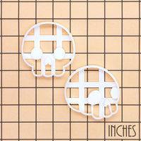 Front and side view cute skull cookie cutters shown on an inch measurement grid