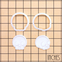 Set of 2 cute skull mini cookie cutter and stamp sets shown on inch measurement grid