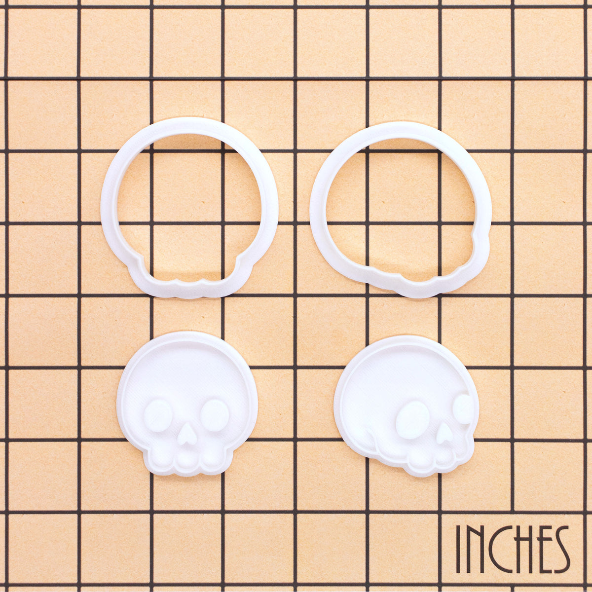 Set of 2 cute skull mini cookie cutter and stamp sets shown on inch measurement grid