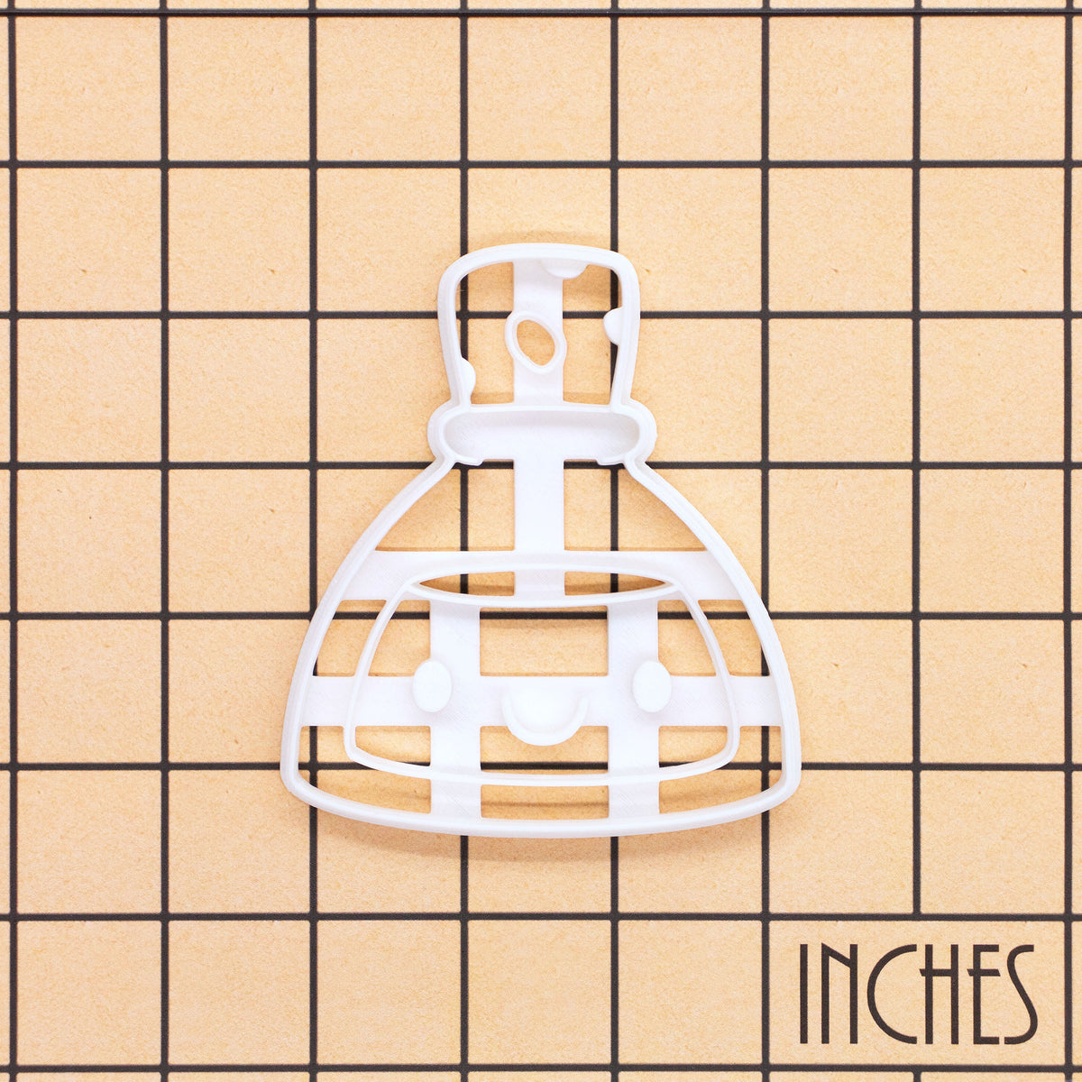 White Smiling Potion cookie cutter on inch grid for Halloween science baking