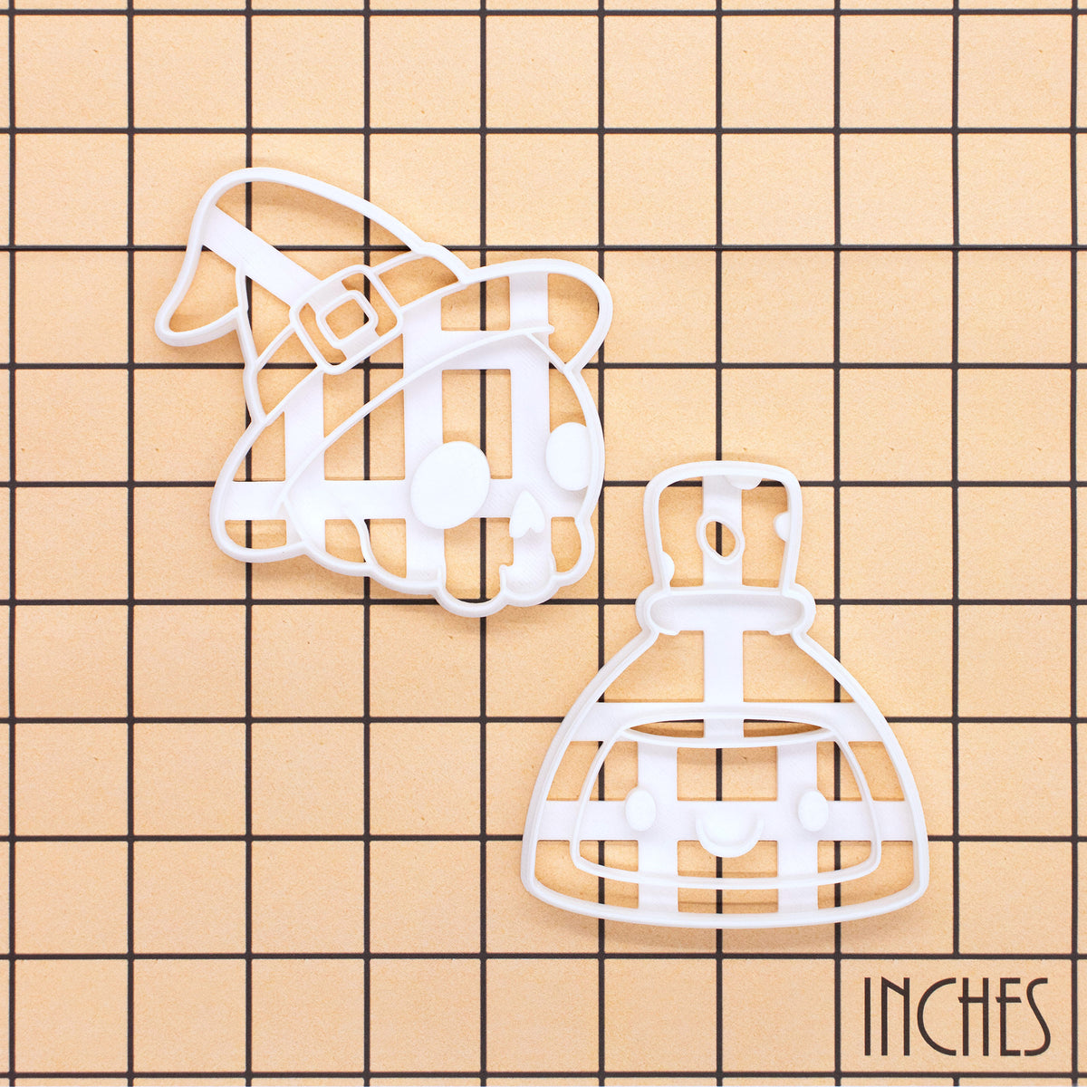 Skull with Witch Hat and Smiling Potion cookie cutter set on inch grid for Halloween baking