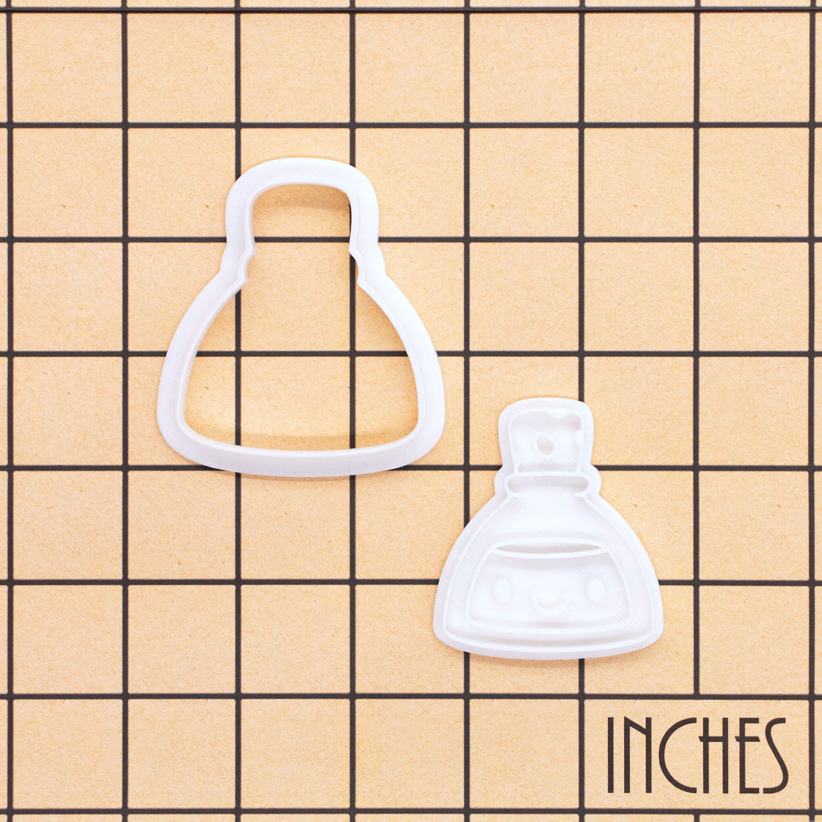 Smiling Potion mini cookie cutter and stamp set on inch grid background