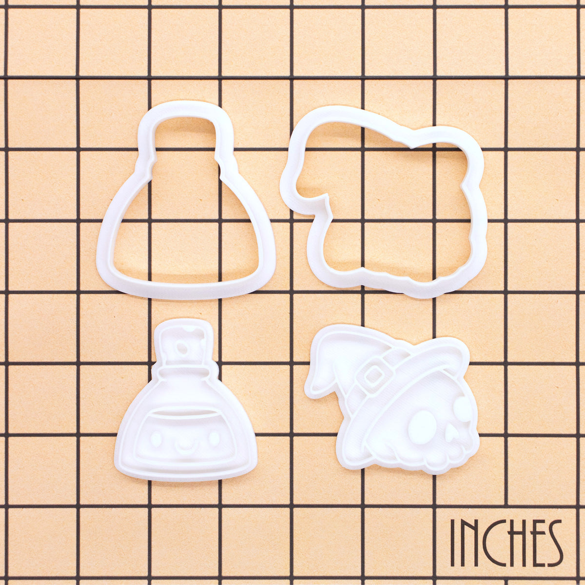 Skull Witch Hat and Smiling Potion Mini cutter and stamp sets on inch grid showing 4 pieces