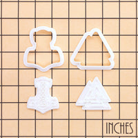 Size guide for Mjolnir and Valknut mini cookie cutter and stamp set displayed on inch grid background