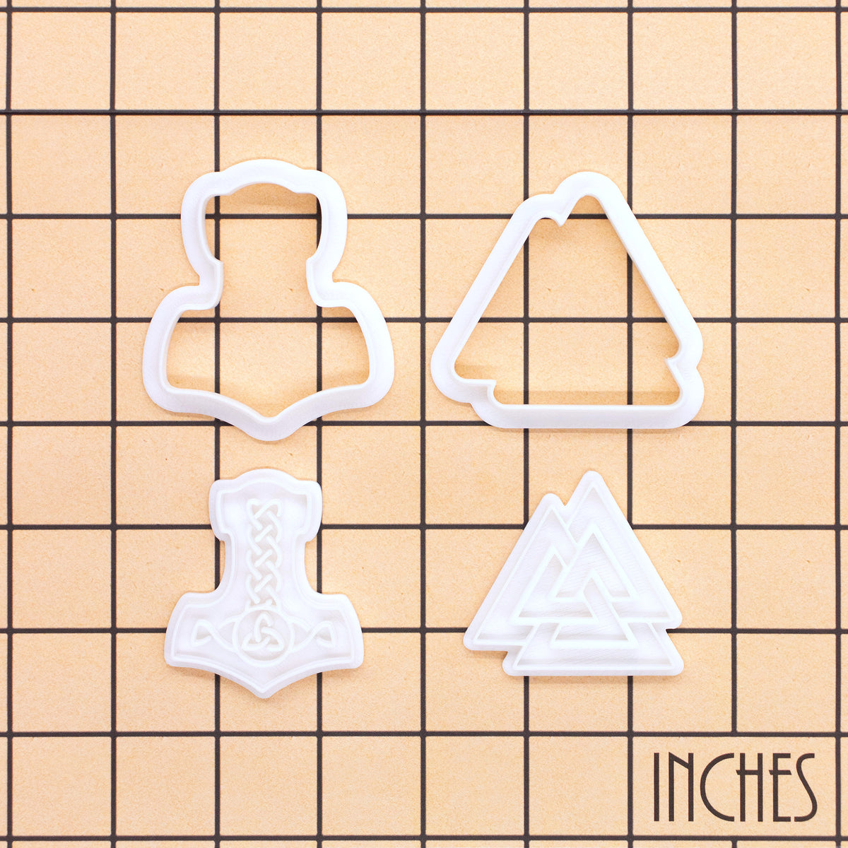 Size guide for Mjolnir and Valknut mini cookie cutter and stamp set displayed on inch grid background