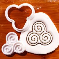 Triskelion mini cookie cutter and impression stamp creating Celtic triple spiral design in rolled fondant