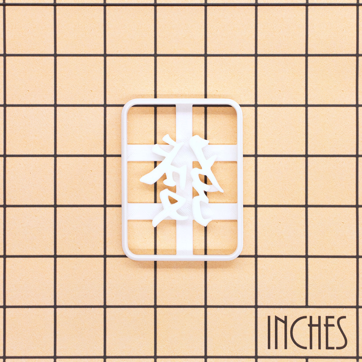 Green Dragon mahjong cookie cutter shown on inch measurement grid
