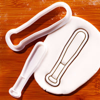 Softball bat mini cookie cutter and impression stamp shown with stamped fondant