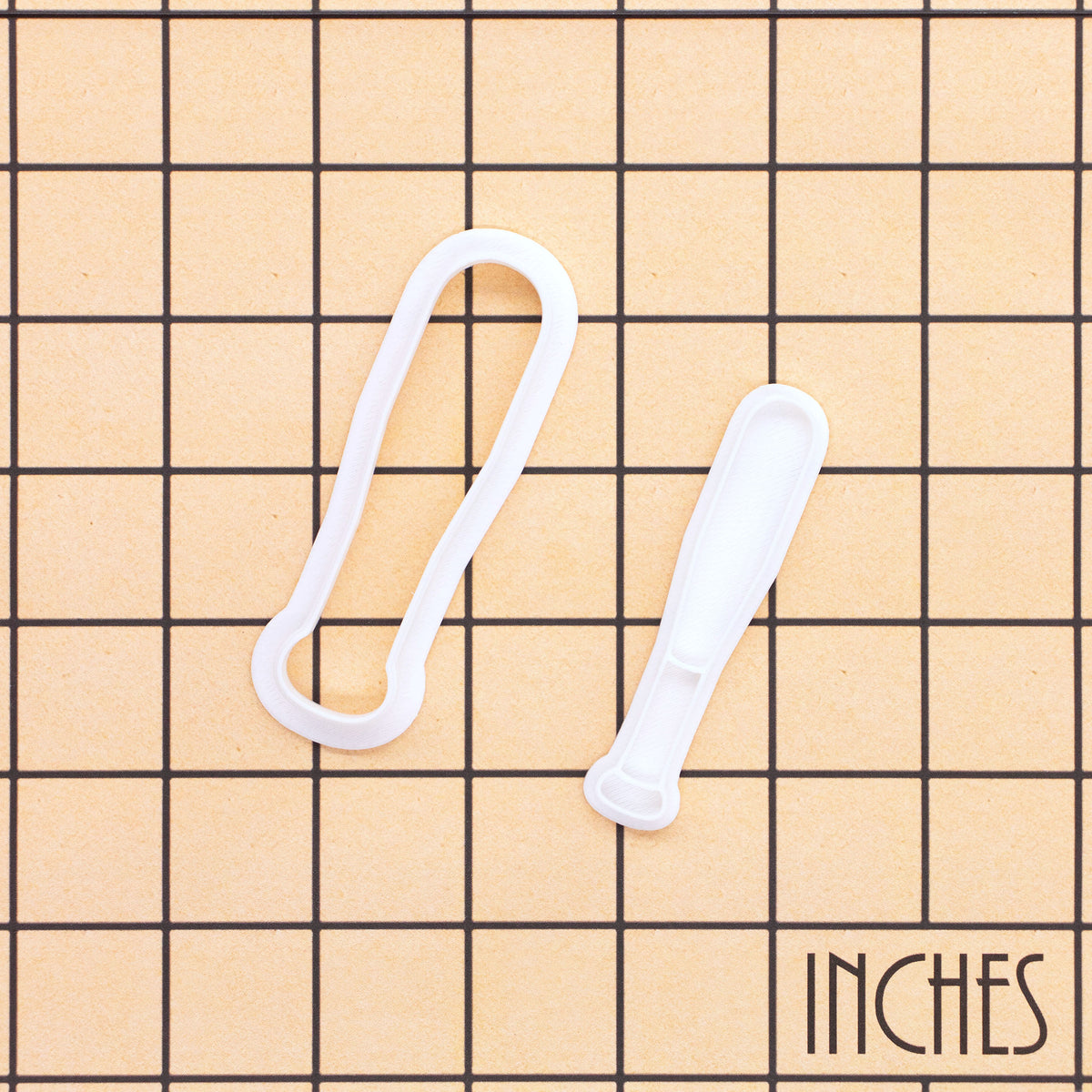 Softball bat mini cookie cutter and stamp set shown on inch measurement grid