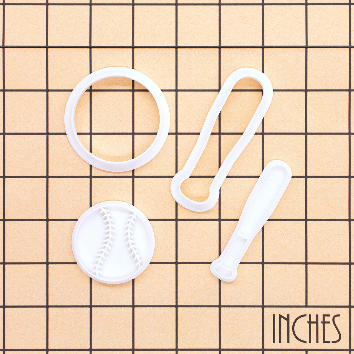 Softball and bat mini cookie cutter and stamp set shown on inch measurement grid