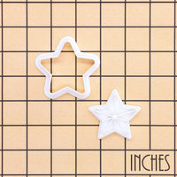 Five-point star mini cookie cutter and stamp set shown on inch grid for baking size reference