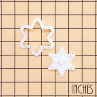 Six-point star mini cookie cutter and stamp set shown on inch grid for size reference