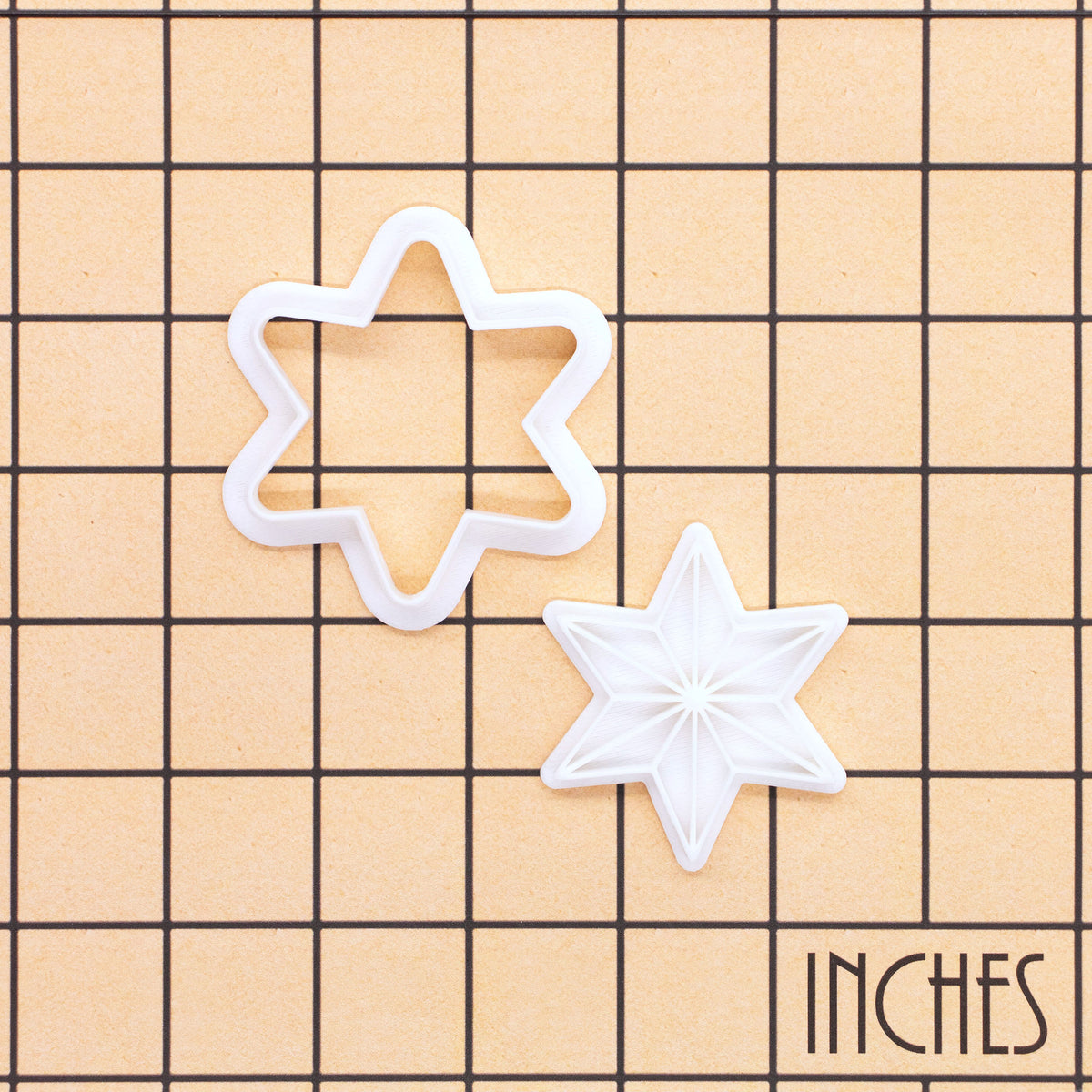 Six-point star mini cookie cutter and stamp set shown on inch grid for size reference