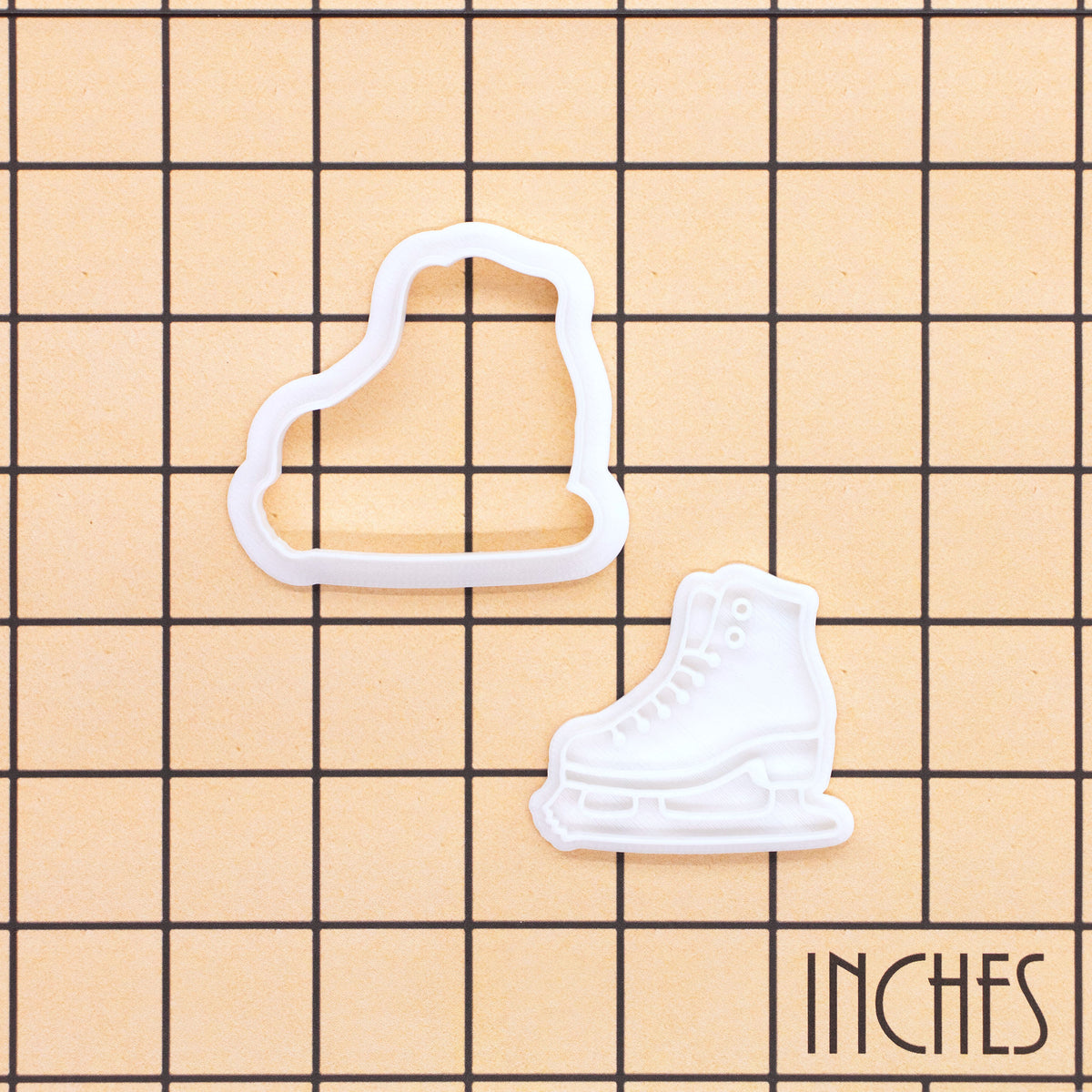 Ice skate mini cookie cutter and stamp set shown on inch grid for size reference