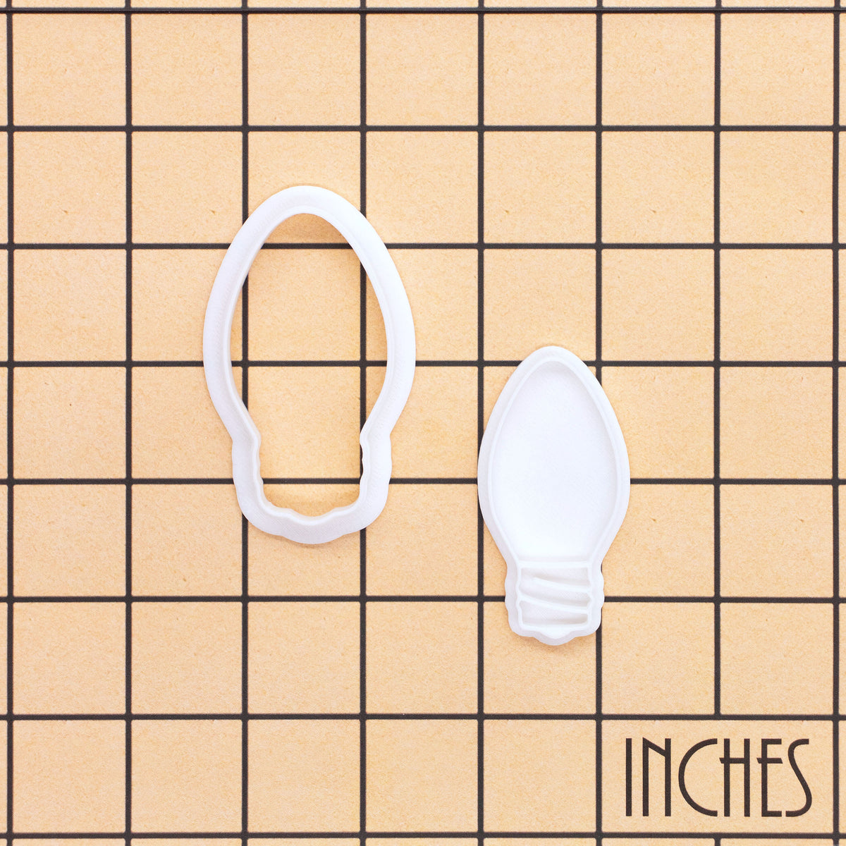 Christmas light bulb mini cookie cutter and stamp set shown on inch grid for size reference