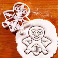 Sheela Na Gig single-piece cookie cutter beside a detailed embossed figure in white fondant