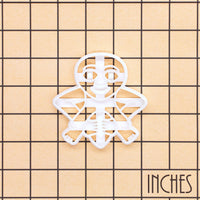Sheela Na Gig figure cookie cutter shown on an inch measurement grid with detailed medieval figure design
