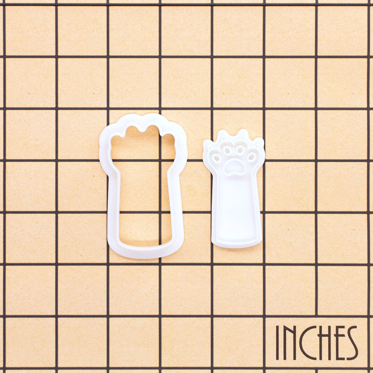 Kitty paw claws mini cookie cutter and separate stamp shown on an inch measurement grid