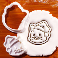 Christmas cat face mini cookie cutter and stamp with Santa hat pressed into fondant
