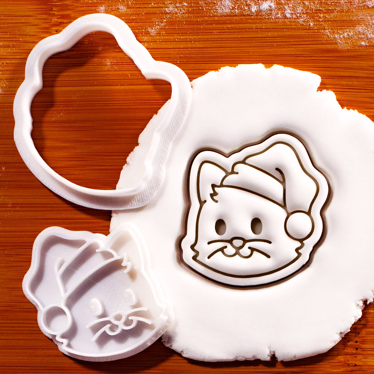 Christmas cat face mini cookie cutter and stamp with Santa hat pressed into fondant