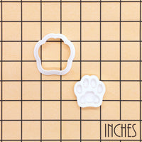 Realistic kitty paw mini cookie cutter and detailed stamp shown on inch measurement grid