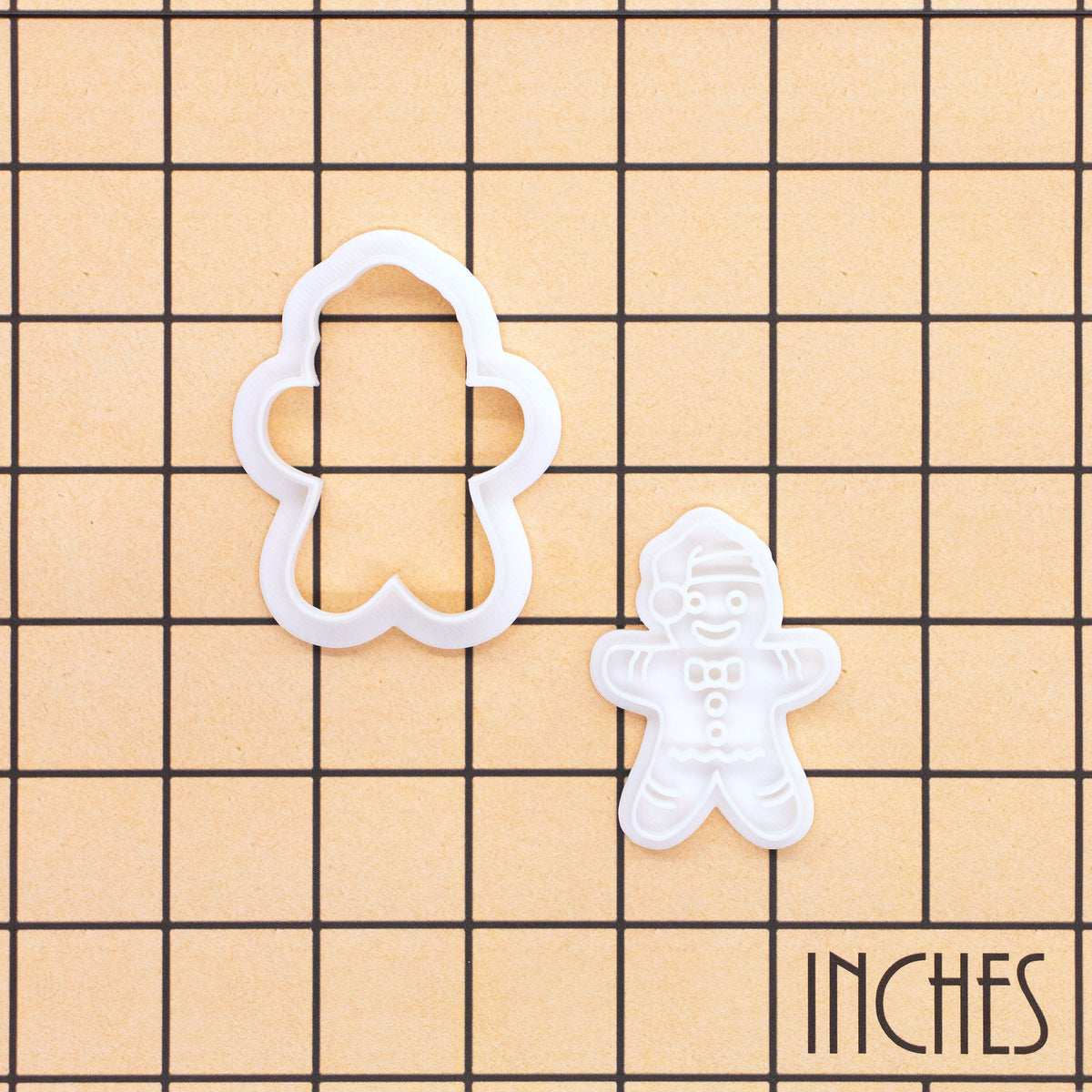 Christmas Gingerbread Man mini cookie cutter and stamp set shown on inch measurement grid