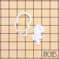 Candy cane bow mini cookie cutter and stamp shown on inch measurement grid