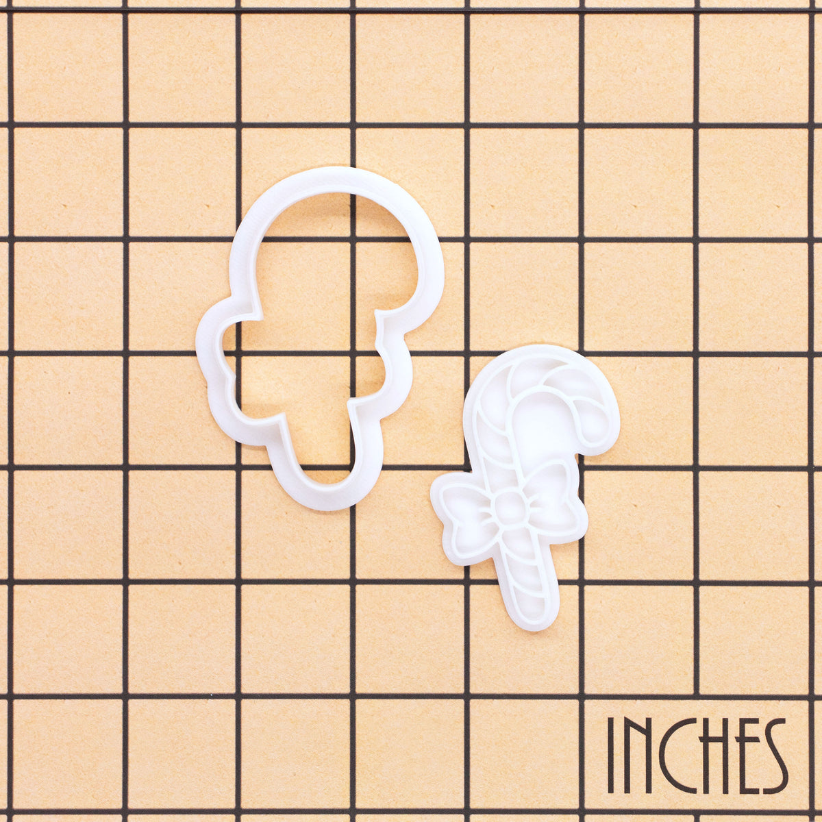 Candy cane bow mini cookie cutter and stamp shown on inch measurement grid
