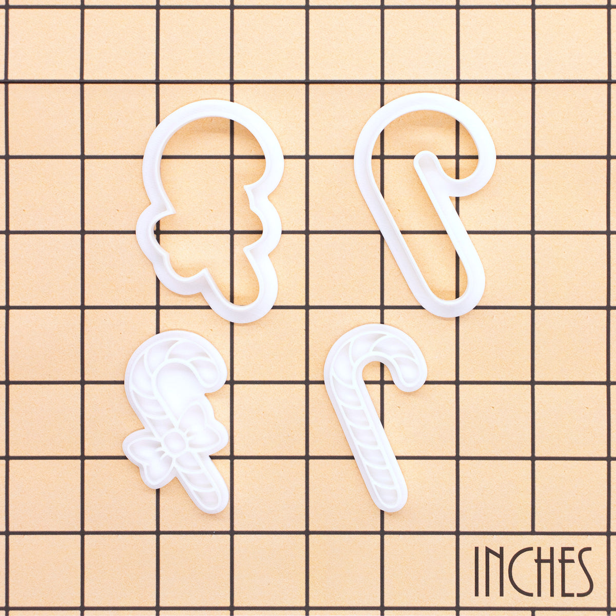 Set of 2 mini candy cane cookie cutters and stamps shown on inch measurement grid