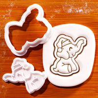 Christmas baby elephant mini cookie cutter and stamp with Santa hat beside embossed sugarpaste impression