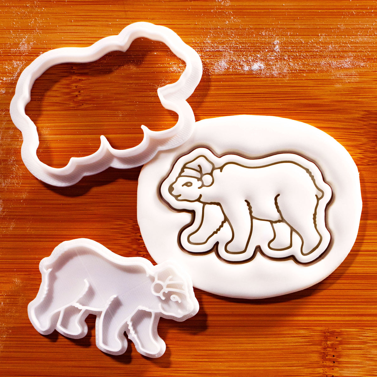 Christmas polar bear mini cookie cutter and detailed stamp beside embossed sugarpaste polar bear impression