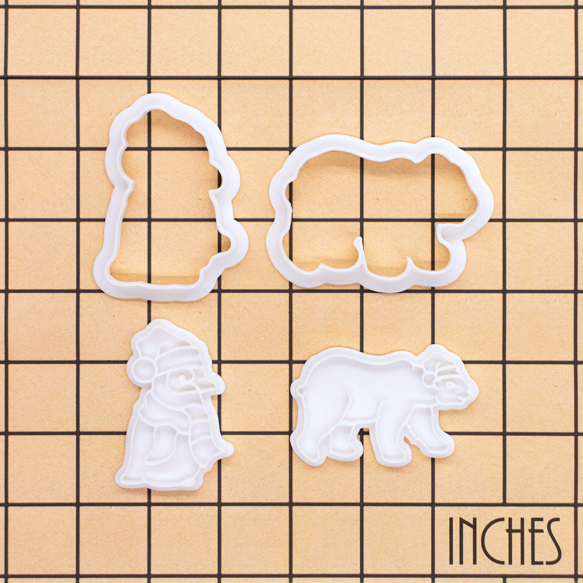 Christmas polar bear and baby penguin mini cookie cutter and stamp set shown on inch measurement grid