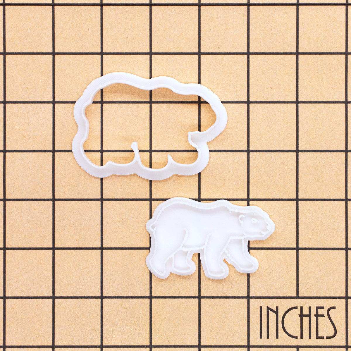 Polar bear mini cookie cutter and stamp set shown on inch measurement grid