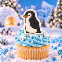 Cute baby penguin fondant cupcake topper on blue winter themed cupcake with snowflake decorations