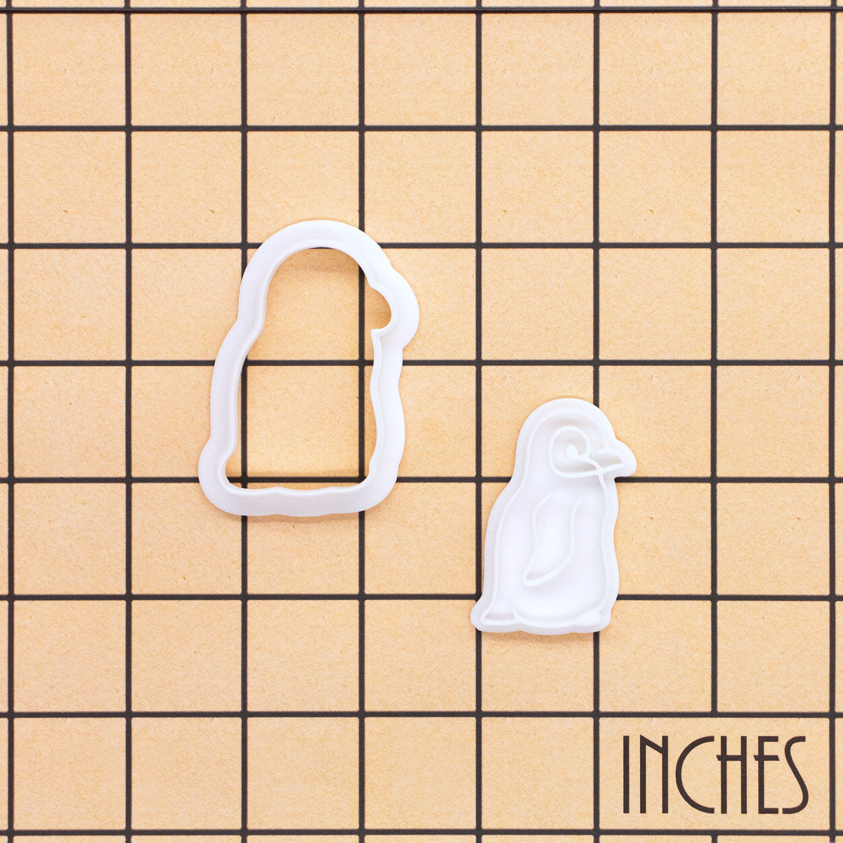 Baby penguin mini cookie cutter and stamp shown on inch measurement grid