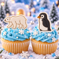 Polar bear and baby penguin fondant cupcake toppers with blue winter icing and snowy Arctic background
