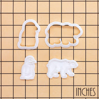 Polar bear and baby penguin mini cookie cutter and stamp set shown on inch measurement grid