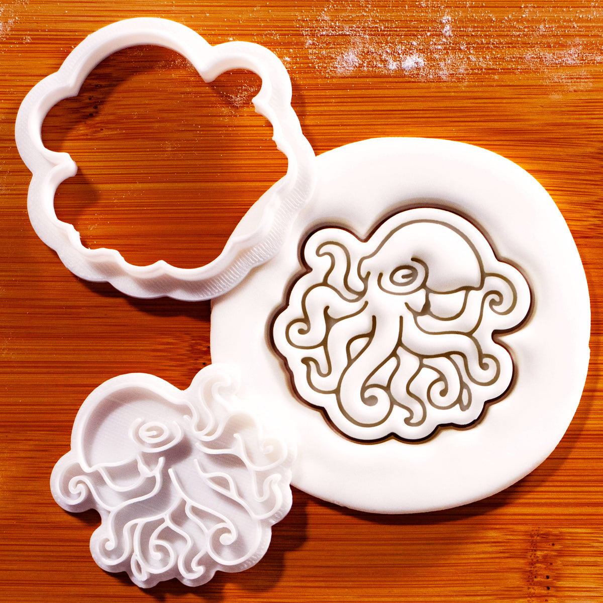 Realistic octopus mini cookie cutter and detailed tentacle stamp beside embossed sugarpaste octopus impression
