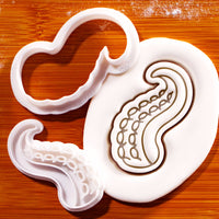 Octopus tentacles mini cookie cutter and suction cup stamp beside detailed sugarpaste tentacle impression