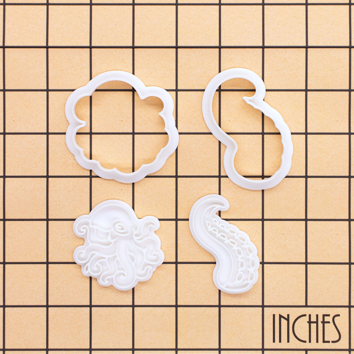 Realistic octopus and tentacles mini cookie cutter and stamp set shown on inch measurement grid