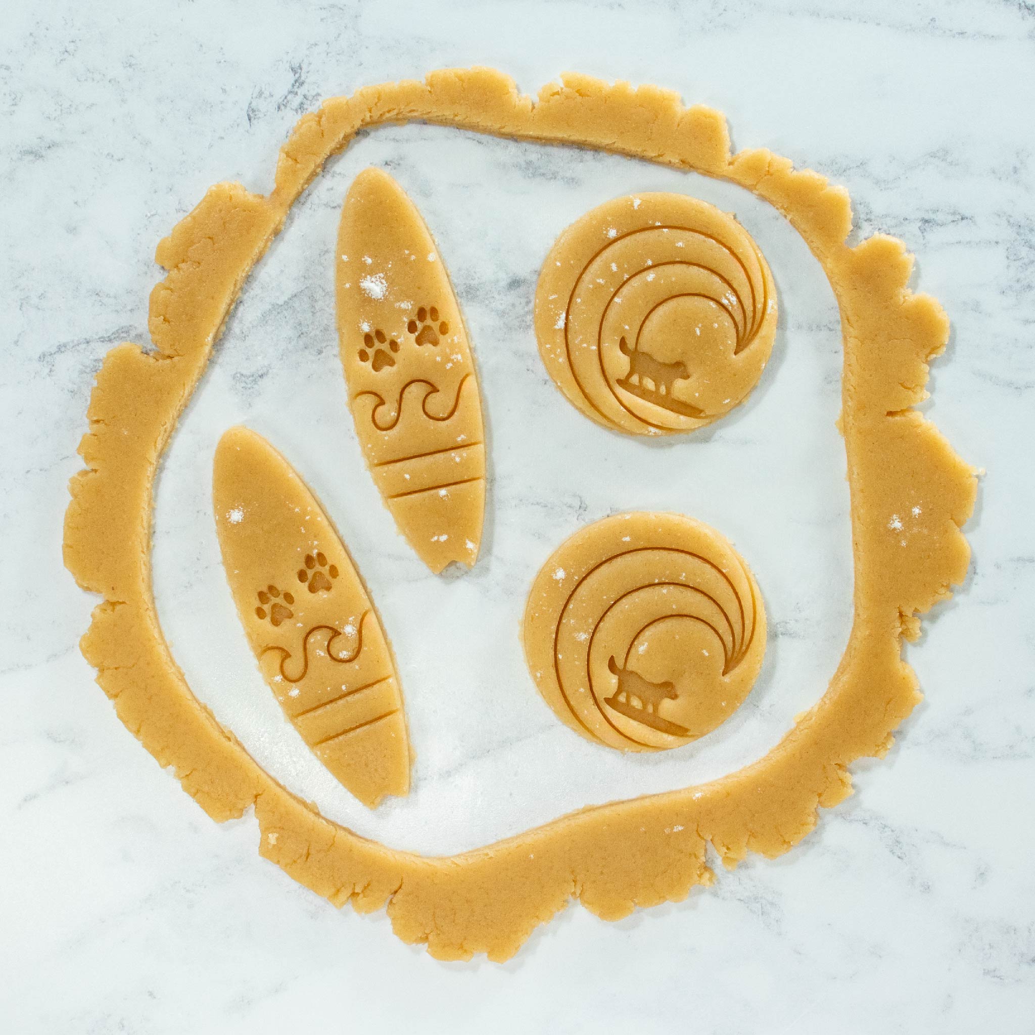 surfer dog and surfboard with paw prints cookies cutout dough made with bakerlogy cookie cutters