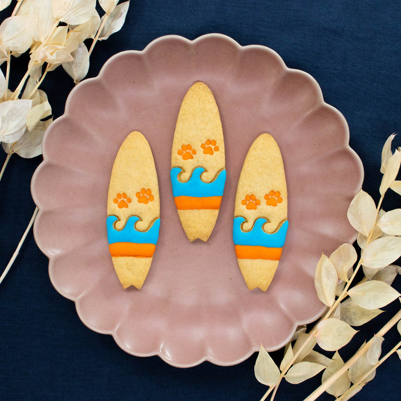 bakerlogy surfboard with paw prints cookies colored with royal icing