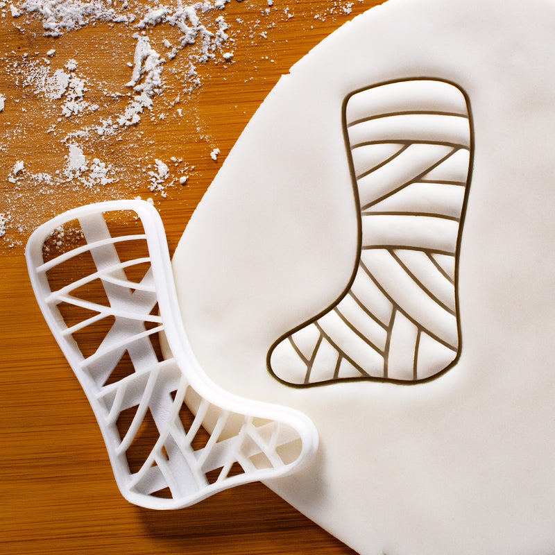 leg cast in bandages cookie cutter pressed on white fondant