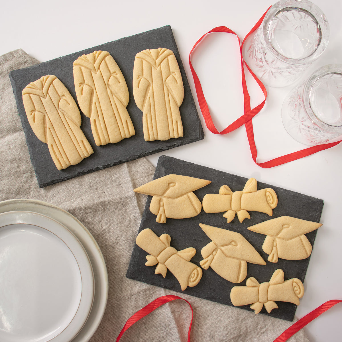 set of 3 graduation themed cookies, featuring a graduation gown, a graduate cap and a scroll