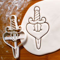 dagger in love shape heart cookie cutter pressed on white fondant