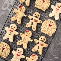 set of 4 cookies, featuring a happy gingerbread man, a zombie gingerbread man, a vitruvian gingerbread man and a voodoo gingerbread man